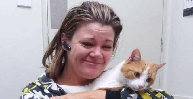 Merry the cat, pictured with relieved owner Stelly Reid, had to be flushed out of a drain with a fire hose.