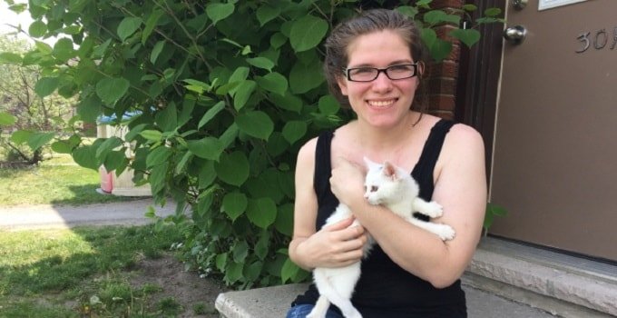 Brooke Seguin and Arwyn, the kitten she found in the backyard of her home on Craig Henry Drive. (Waubgeshig Rice/CBC)